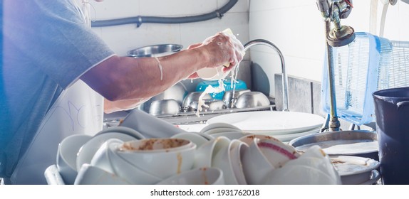 Man Washing Dish In Sink At Restaurant.People Are Washing The Dishes Too Cleaning Solution