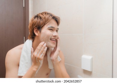 Man Washing Face With Facial Cleanser Face Wash Soap In Bathroom Sink At Home.