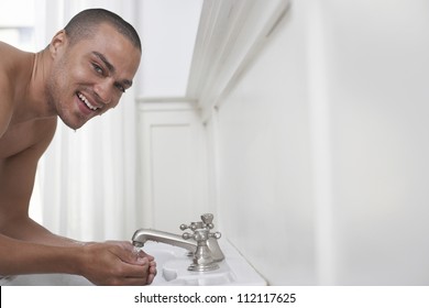 Man Washing Face In Sink