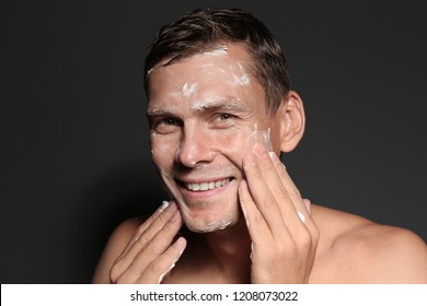 Man Washing Face With Soap On Dark Background