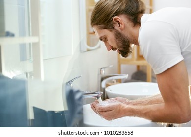 Man Washing Face. Young Male Cleaning Face In Bathroom. Portrait Of Handsome Man With Beard Washing Face Skin With Clean Water Over Bathroom Sink In Morning. Hygiene. High Quality Image. - Powered by Shutterstock