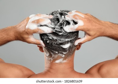 Man Washing Hair On Grey Background, Back View