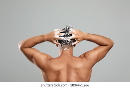 Man Washing Hair On Grey Background, Back View