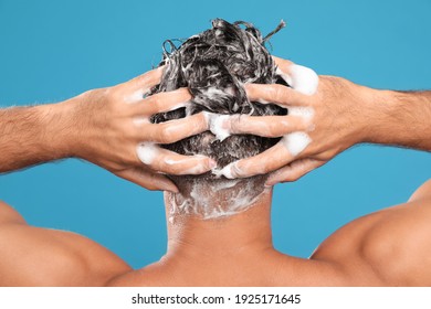 Man Washing Hair On Light Blue Background, Back View