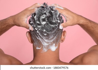 Man Washing Hair On Pink Background, Back View