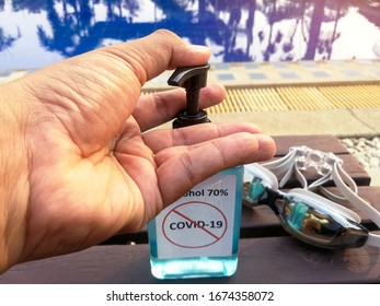 Man washing hand with Alcohol 70% Sanitizer for protect corona virus or covid-19 in swimming pool.