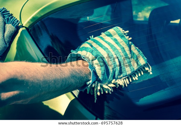 Man washing his green car - car washing and\
car cleaning concept - retro\
style