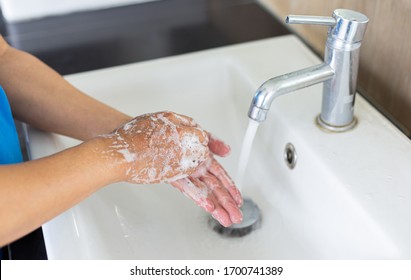 Man is washing his hands in a sink sanitizing the colona virus for sanitation and reducing the spread of COVID-19 spreading throughout the world, Hygiene ,Sanitation concept. - Shutterstock ID 1700741389