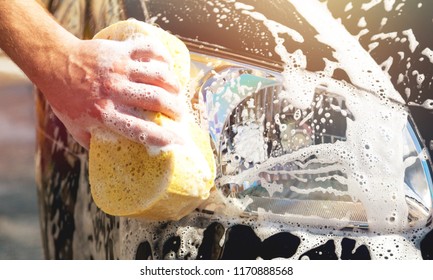 Man Washing A Soapy  Car With A Yellow Sponge.