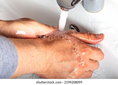 Man Washing Soapy Hands In Bathroom - Close Up View