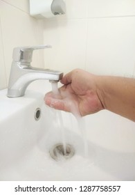 Man washing their hands in the sink