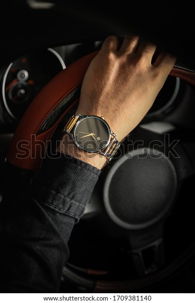 man\
watches the luxury wrist watch from inside the\
car