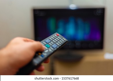 A Man Watches Tv And Holds The Shift Control With His Left Hand.