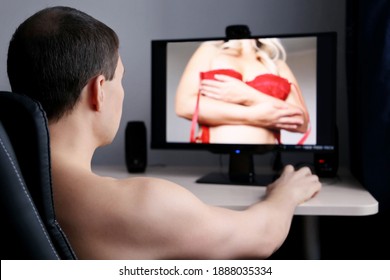 Man watching adult photo or video on PC display sitting in office chair. Concept of porn movies, home leisure