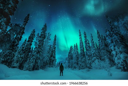 Man watching Aurora borealis in lapland winter