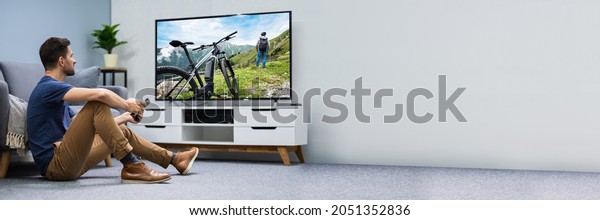 Man Watching\
Connected TV Screen In Living\
Room
