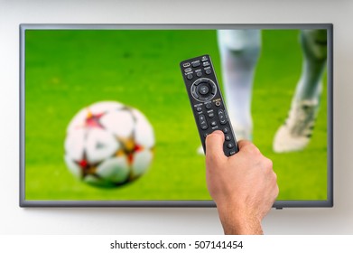 Man is watching football match on TV and holding tv remote controller in hand - Shutterstock ID 507141454