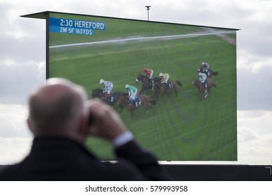 Man watching horse racing through binoculars - Shutterstock ID 579993958