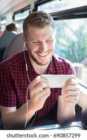 Man Watching Movie On Mobile Phone During Journey To Work