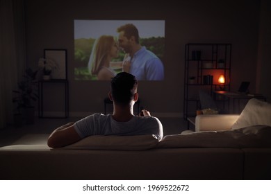 Man Watching Movie On Sofa At Night, Back View