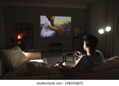 Man Watching Movie On Sofa At Night, Back View. Space For Text