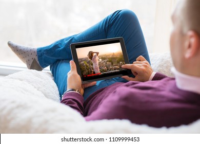 Man watching movie on tablet at home.