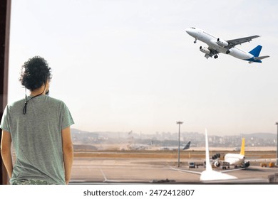 Man watching planes taking off from airport window. Aviation idea concept. Tourist or passenger waiting for his flight. Aircraft. Airlines. Horizontal photo. People, model, person. Sky.  - Powered by Shutterstock