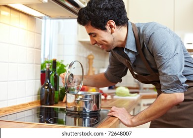 Man Watching A Pot On A Stove In The Kitchen