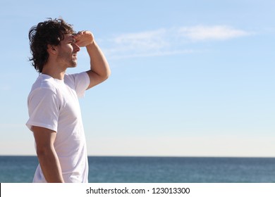 Man watching the sea with his hand in the forehead