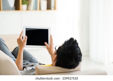 Man Watching Something On Digital Tablet At Home