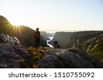 Man watching sunset at Western Brook Pond in Gros Morne National Park, Newfoundland, Canada