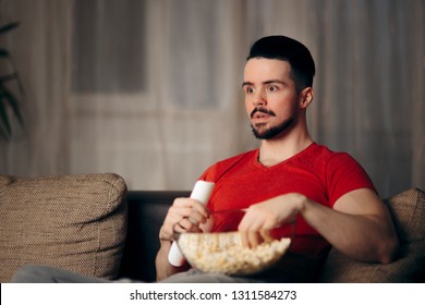 Man Watching TV Eating Pop Corn. Young Millennial Guy Stress Eating Binging On Favorite Show
