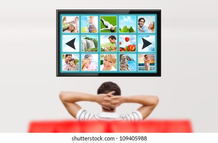 Man Watching Tv. Photo From Behind. Editable Copyspace At The Screen