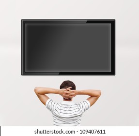 Man Watching Tv. Photo From Behind. Editable Copyspace At The Screen