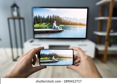 Man Watching TV Streaming From Smartphone Or Mobile Phone - Shutterstock ID 1890412717