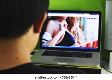 Man watching video of sexy women in notebook screen, blur concept.