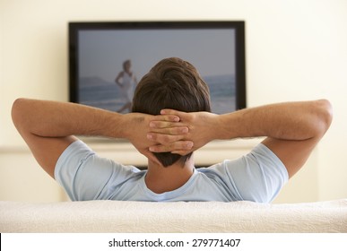 Man Watching Widescreen TV At Home