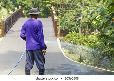 A Man Watering The Garden.