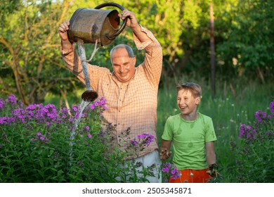 A man waters flowers with a watering can while his grandson watches and laughs. The scene is peaceful and serene, the two men enjoying the simple pleasure of tending to a garden. - Powered by Shutterstock