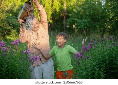 A man waters flowers with a watering can while his grandson watches and laughs. The scene is peaceful and serene, the two men enjoying the simple pleasure of tending to a garden. - Powered by Shutterstock