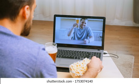 Man Waving At His Friend During A Video Call In Timp Of Covid-19 And Beer On The Table.