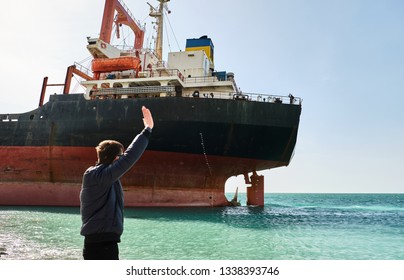 A Man Waving To The Sailors On The Ship. Cargo Ship Rio Ran Aground Off The Coast Of Novorossiysk