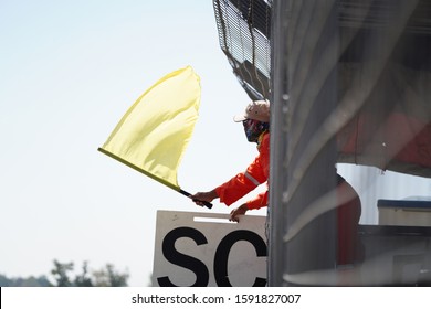 Man Waving Yellow Flag On Racetrack