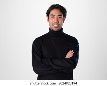 A man wear black turtleneck shirt do the crossarm action and smile to the camera on white background.