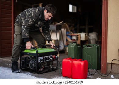 Man wear in military jacket with gasoline portable mobile backup standby generator. - Shutterstock ID 2240151989