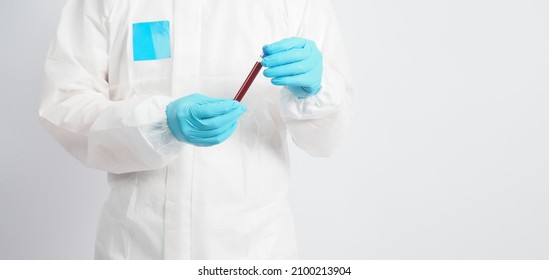 Man wear PPE suite and Hand wear medical glove is holding blood tube on white background. - Shutterstock ID 2100213904
