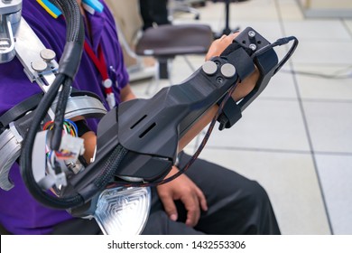 Man Wear Robot Arm For Physical Therapy. By Defining How A Robot Driven Moving Technique Can Be Improved To Achieve Better Results In Physical Rehabilitation.