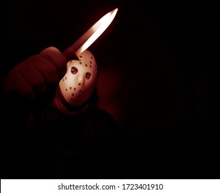 Man Wear White Hockey Mask With One  Knife  On A Black Background