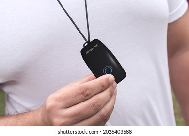 A man wearing a air purifier necklace. A small portable purifying device generating ozone, which is popular yet without scientific evidence of effectiveness.. - Shutterstock ID 2026403588