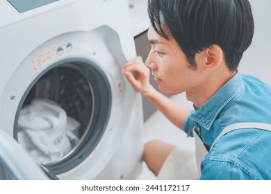 Man wearing apron doing laundry - Powered by Shutterstock